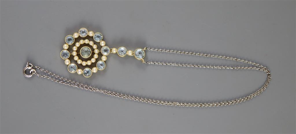 An Edwardian 15ct gold, aquamarine and seed pearl set circular drop pendant necklace,